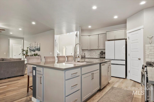 kitchen with a kitchen island with sink, sink, gray cabinetry, and stainless steel appliances