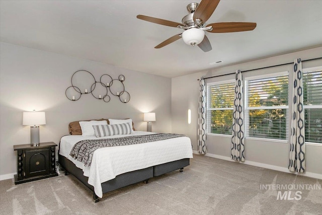 carpeted bedroom featuring ceiling fan and multiple windows