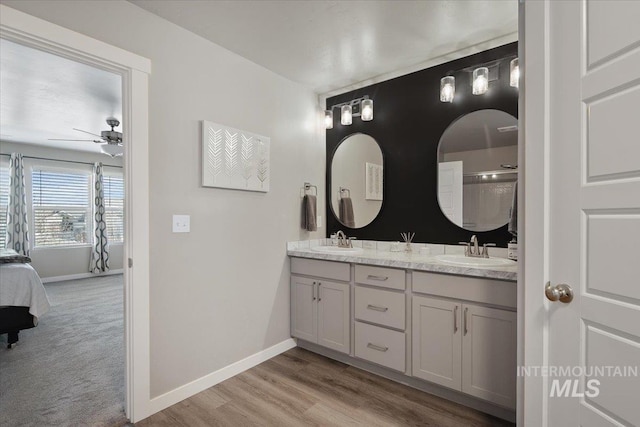 bathroom featuring ceiling fan, hardwood / wood-style floors, and vanity