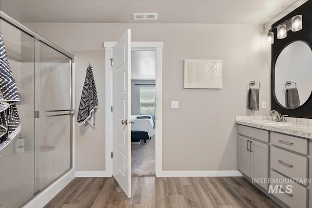 bathroom featuring vanity, hardwood / wood-style floors, and a shower with door