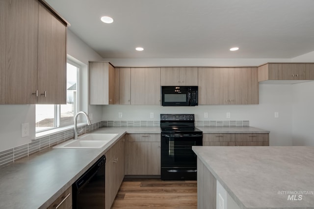 kitchen featuring light hardwood / wood-style floors, light brown cabinets, black appliances, and sink