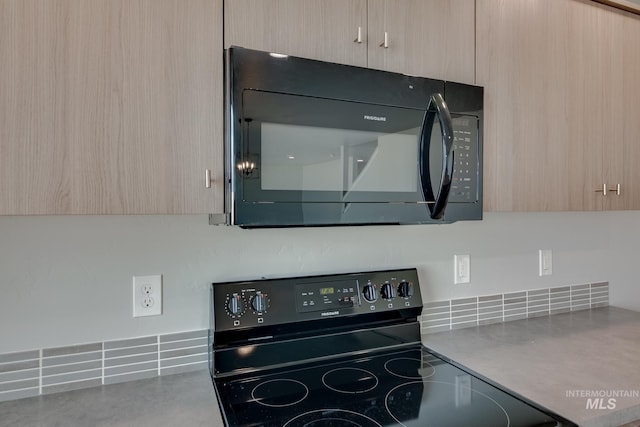 kitchen with light brown cabinetry and black appliances