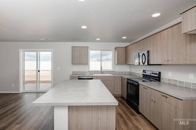 kitchen with light brown cabinetry, plenty of natural light, dark wood-type flooring, and black appliances