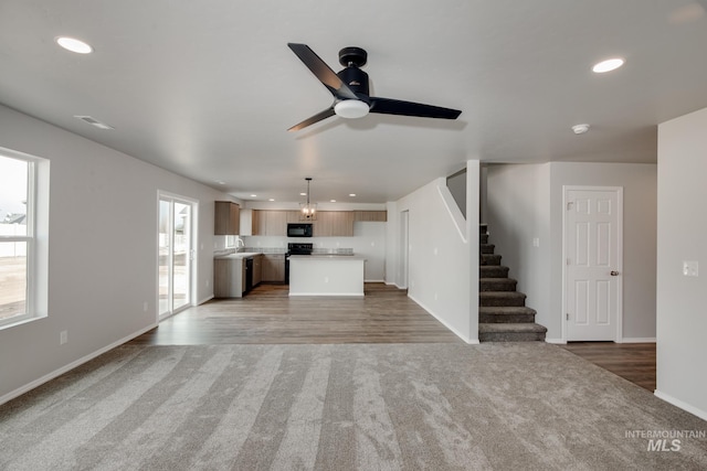 unfurnished living room featuring wood-type flooring and ceiling fan