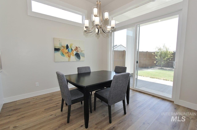 dining area with wood-type flooring and a notable chandelier