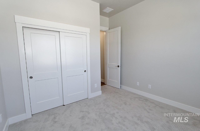 unfurnished bedroom featuring a closet and light carpet