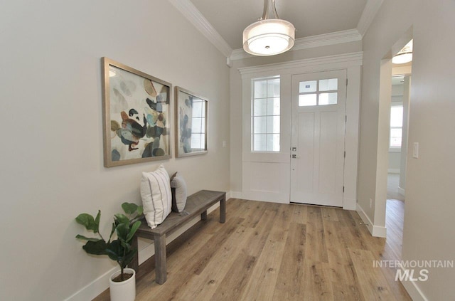 foyer entrance with crown molding and light hardwood / wood-style floors