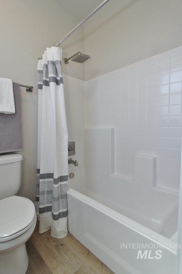 bathroom featuring toilet, shower / bath combo with shower curtain, and wood-type flooring