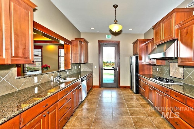 kitchen featuring pendant lighting, appliances with stainless steel finishes, sink, backsplash, and light tile patterned floors