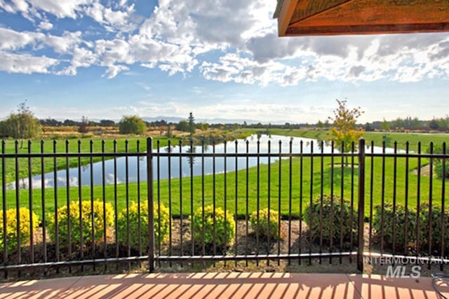 view of gate with a yard and a water view