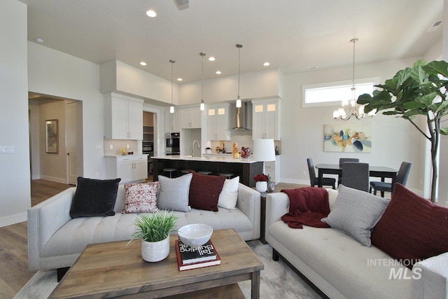 living room featuring sink, a chandelier, and hardwood / wood-style floors