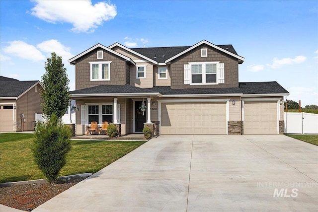 craftsman house with fence, covered porch, concrete driveway, an attached garage, and a front yard