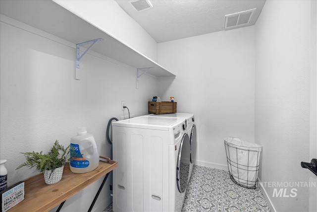 laundry area featuring visible vents, baseboards, separate washer and dryer, and laundry area