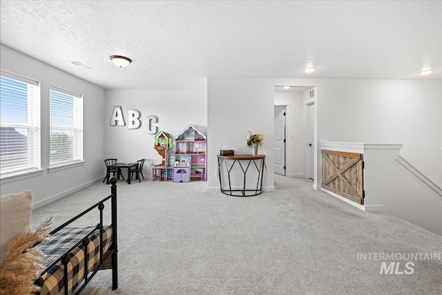 living area with baseboards, visible vents, a textured ceiling, carpet flooring, and an upstairs landing