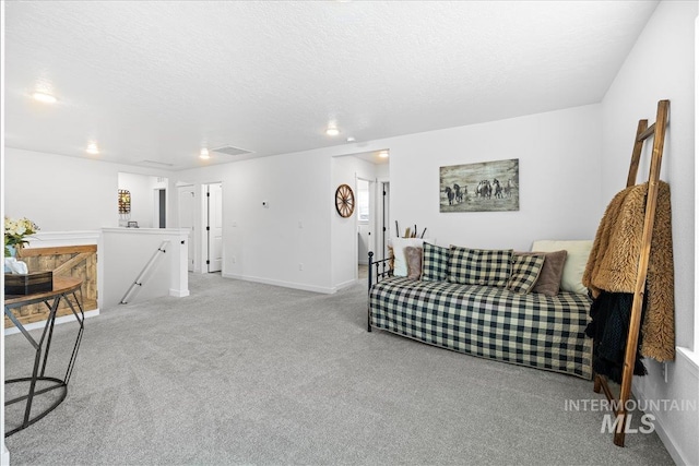 carpeted living room with baseboards, visible vents, and a textured ceiling