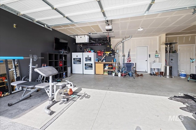 garage with a sink, a garage door opener, and freestanding refrigerator