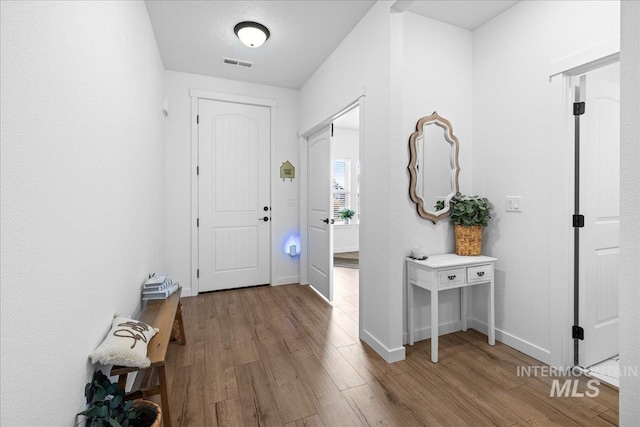 entrance foyer with visible vents, baseboards, and wood finished floors