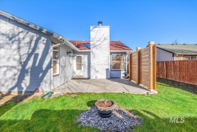 rear view of property featuring a patio area and a lawn