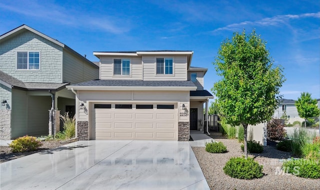 2252 E Tiger Lily Dr, Boise, ID 83716 - view of front of house featuring an attached garage, concrete driveway, stone siding, and a shingled roof