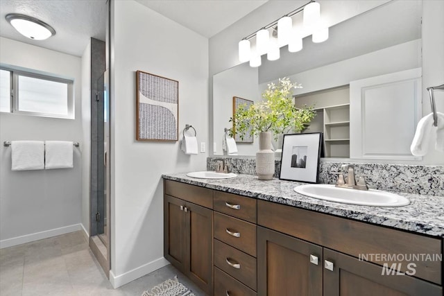 2252 E Tiger Lily Dr, Boise, ID 83716 - bathroom featuring baseboards, double vanity, a shower stall, and backsplash