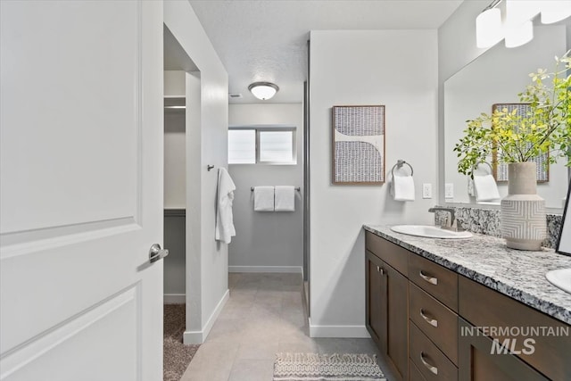 2252 E Tiger Lily Dr, Boise, ID 83716 - full bath with double vanity, baseboards, and tile patterned flooring