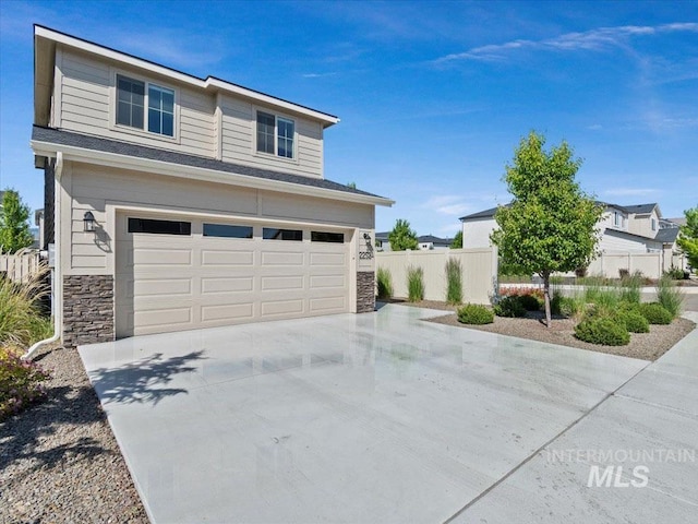 2252 E Tiger Lily Dr, Boise, ID 83716 - view of front facade featuring an attached garage, stone siding, and concrete driveway