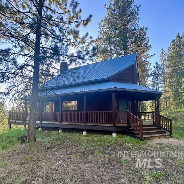 51 Ranch Cir, Cascade, ID 83611 - view of front of house with a porch, a chimney, and metal roof