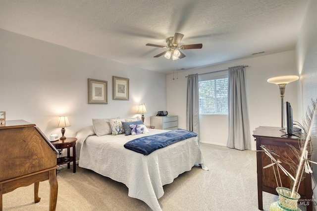 bedroom with light carpet, a ceiling fan, and a textured ceiling