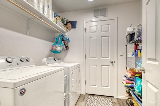 laundry area featuring separate washer and dryer and light wood-style flooring
