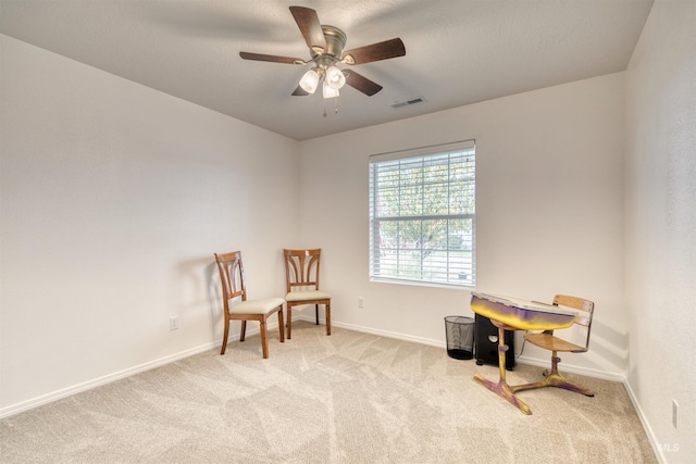living area with carpet floors, a ceiling fan, and baseboards