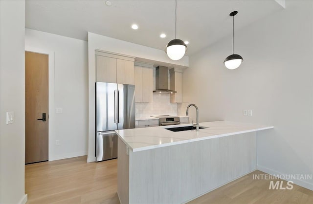 4340 E Haystack St Unit 304, Boise, ID 83716 - kitchen with appliances with stainless steel finishes, wall chimney exhaust hood, a peninsula, light wood-style floors, and recessed lighting
