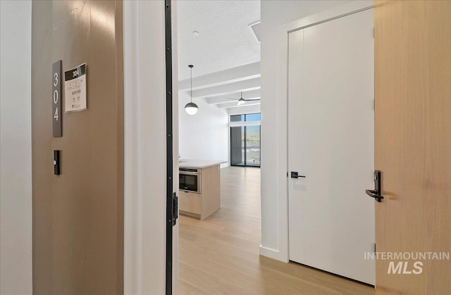 4340 E Haystack St Unit 304, Boise, ID 83716 - hallway with light wood-style flooring and beamed ceiling