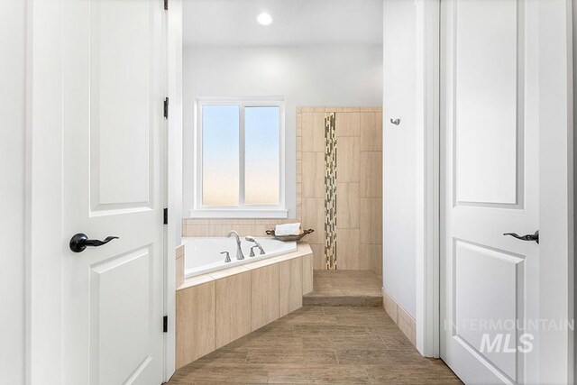 bathroom featuring hardwood / wood-style floors and tiled bath