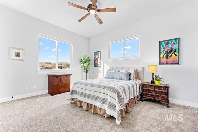 bedroom featuring ceiling fan, multiple windows, and light carpet