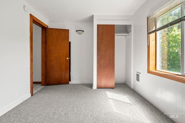 unfurnished bedroom with carpet, a closet, and baseboards