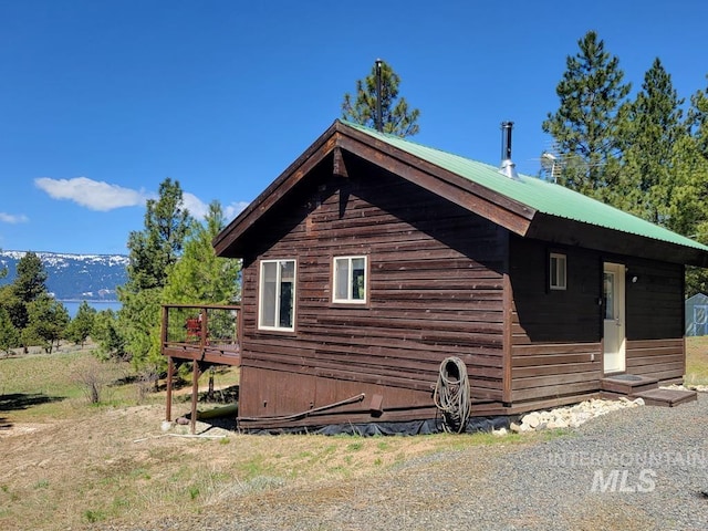 view of property exterior with metal roof and a wooden deck