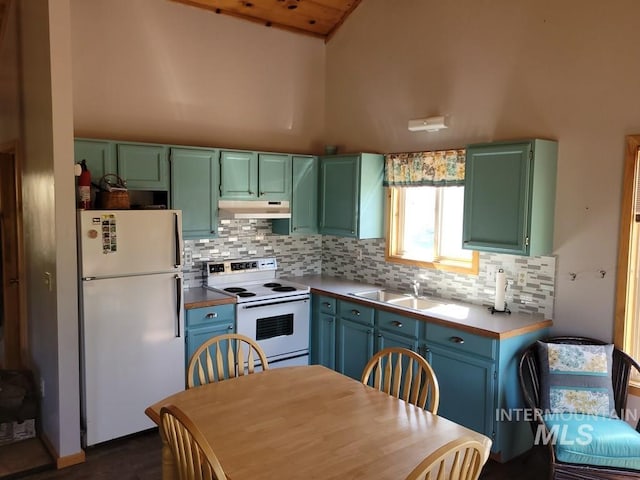 kitchen featuring a sink, white appliances, tasteful backsplash, under cabinet range hood, and light countertops