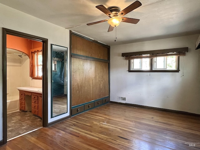 278 Taylor St, Twin Falls, ID 83301 - unfurnished bedroom with dark wood-style flooring, ensuite bathroom, baseboards, and ceiling fan