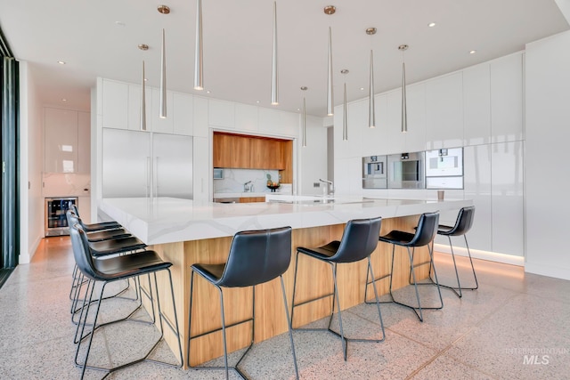 kitchen with a breakfast bar, white cabinetry, a spacious island, and wine cooler