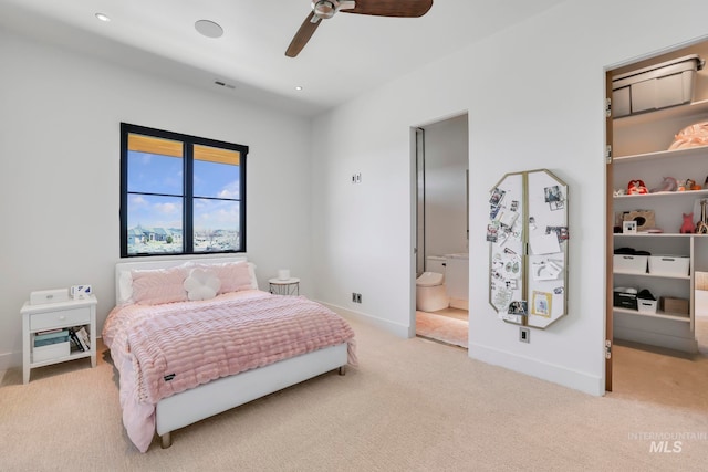 carpeted bedroom with ceiling fan and ensuite bath