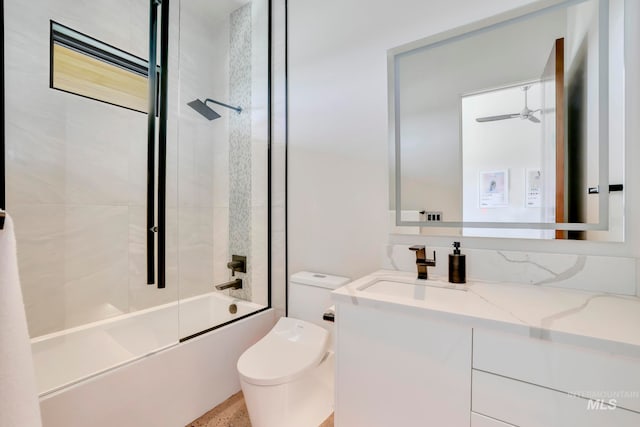 full bathroom featuring combined bath / shower with glass door, vanity, toilet, and ceiling fan