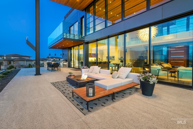 view of patio / terrace with an outdoor living space with a fire pit and a balcony