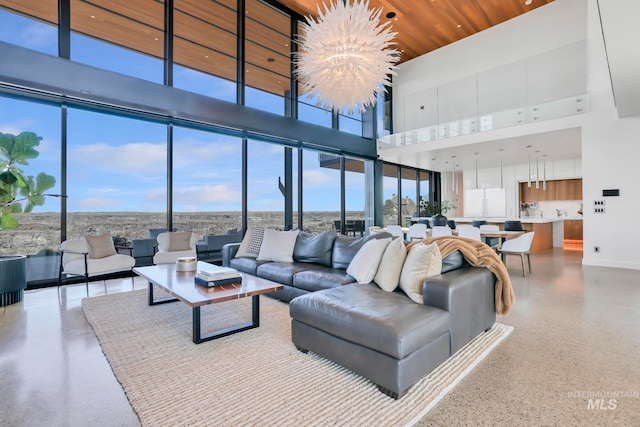 living room featuring a wealth of natural light, a high ceiling, and a chandelier