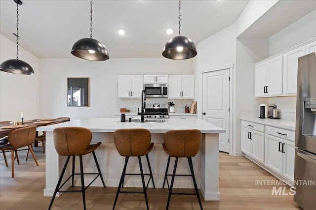 19321 Geneva Way, Caldwell, ID 83605 - kitchen featuring light countertops, an island with sink, a kitchen breakfast bar, and stainless steel appliances