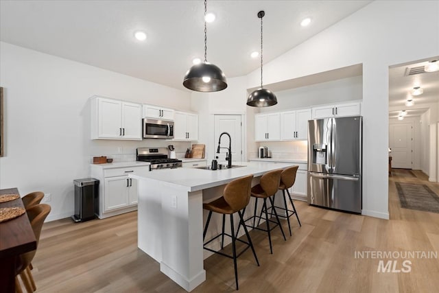19321 Geneva Way, Caldwell, ID 83605 - kitchen with stainless steel appliances, a kitchen breakfast bar, a sink, light wood-style floors, and light countertops