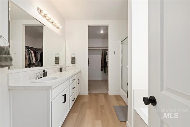 19321 Geneva Way, Caldwell, ID 83605 - bathroom featuring a spacious closet, wood finished floors, a sink, and double vanity