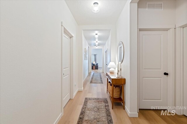 19321 Geneva Way, Caldwell, ID 83605 - hall with light wood-style floors, visible vents, and baseboards
