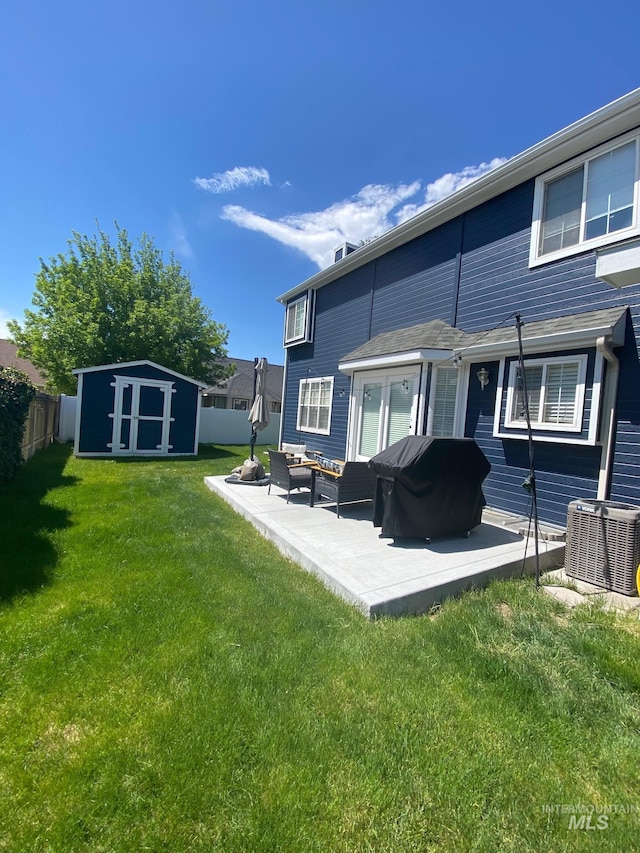 rear view of house featuring cooling unit, an outdoor structure, a fenced backyard, a shed, and a patio area