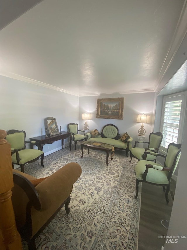 living room with baseboards, crown molding, and wood finished floors