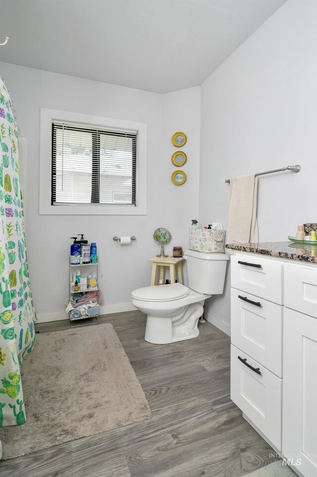 1713 Blaine St, Caldwell, ID 83605 - bathroom with toilet, wood finished floors, baseboards, vanity, and a shower with shower curtain